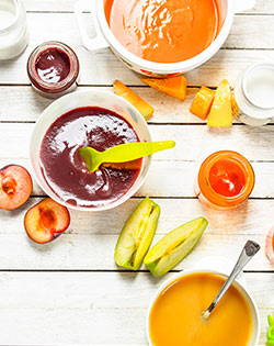 BABY PUREE ON TABLE WITH CUT FRUIT