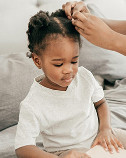 LITTLE GIRL GETTING HAIR BRAIDED