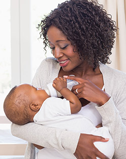 MÃE A ALIMENTAR O BEBÉ COM O BIBERÃO