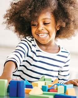 GIRL WITH AFRO SMILING AND LOOKING DOWN