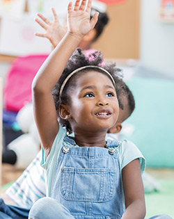 GIRL IN CLASS PUTTING UP HER HAND